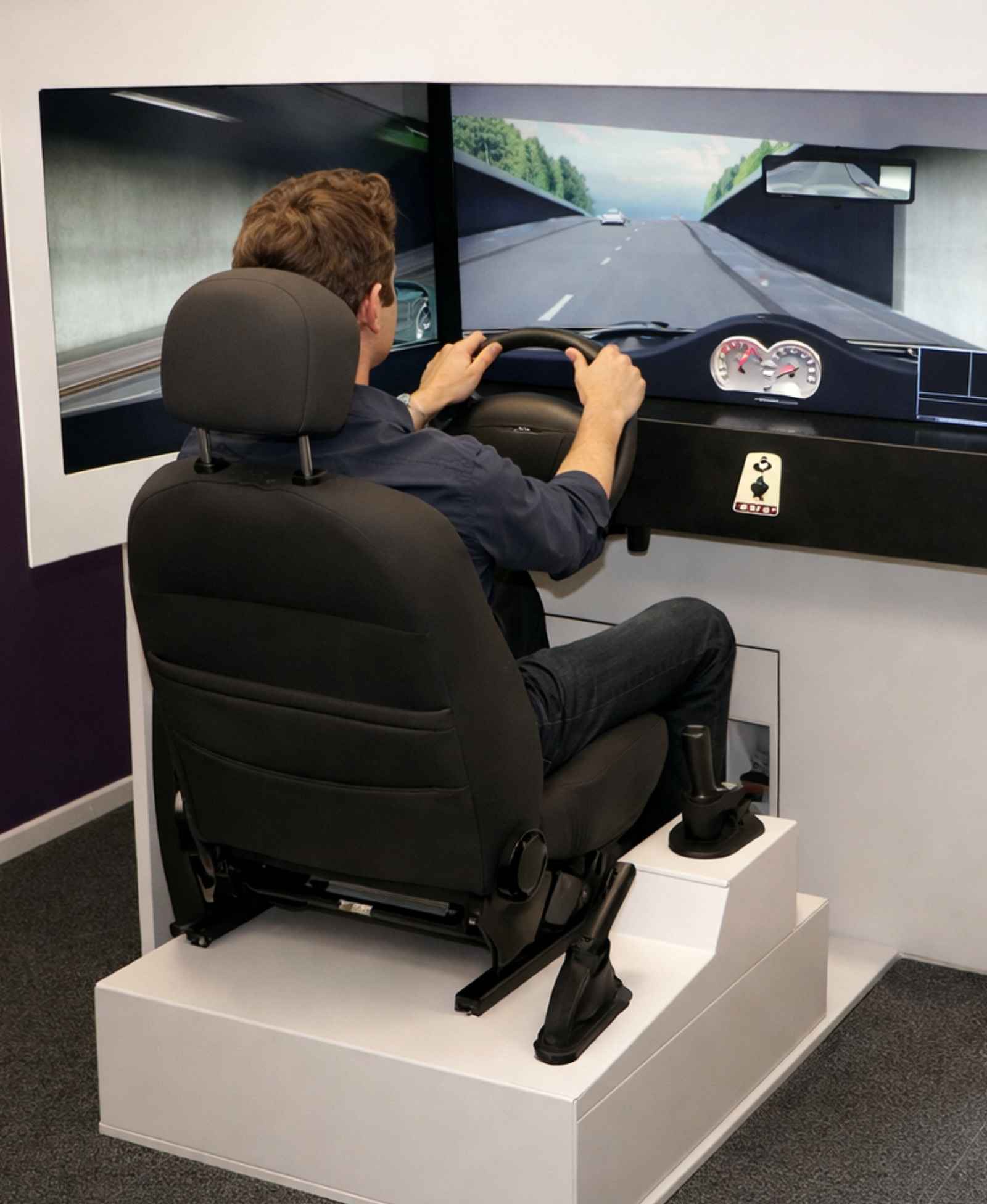 Een jongen die bezig is met de rijsimulator